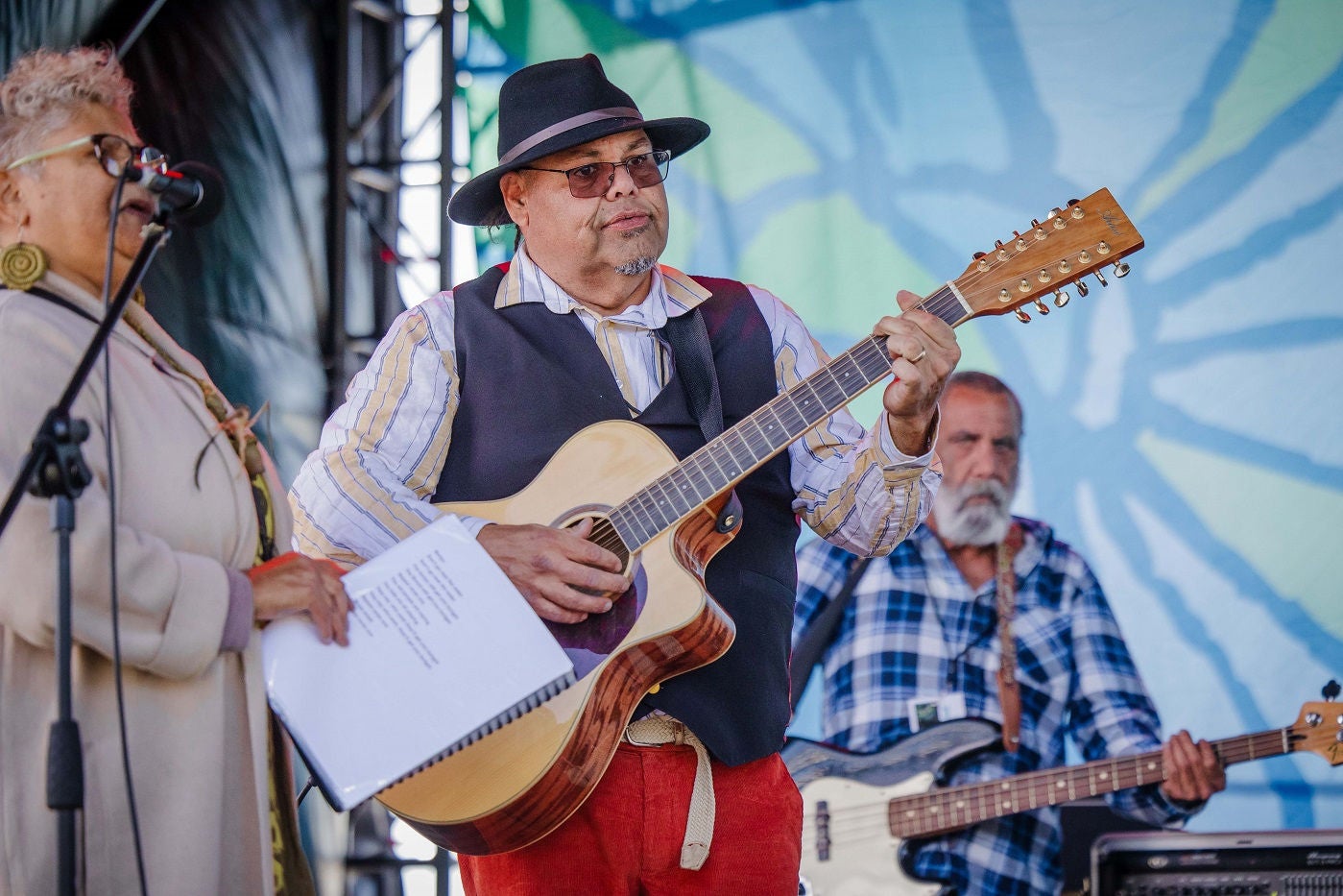 Musicians at the Saltwater Freshwater Festival. The musicians in the middle and on the right are playing guitars.