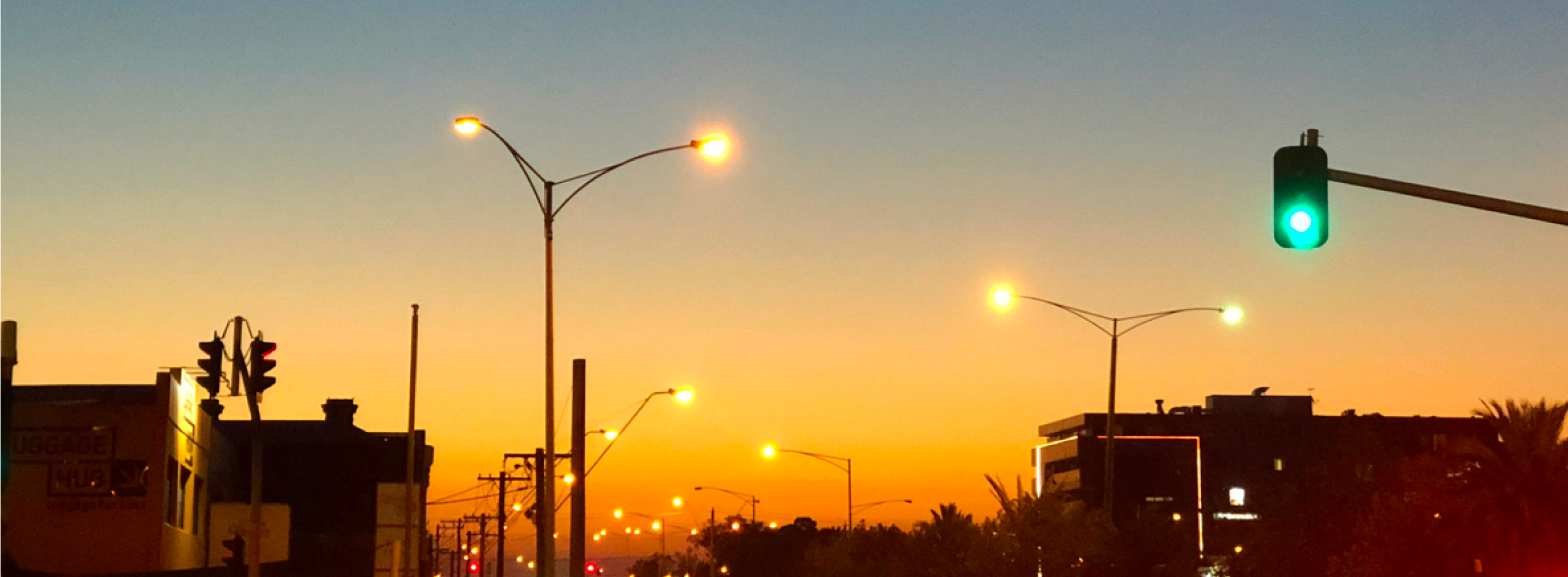 Skyline of a street at sunset with streetlights on