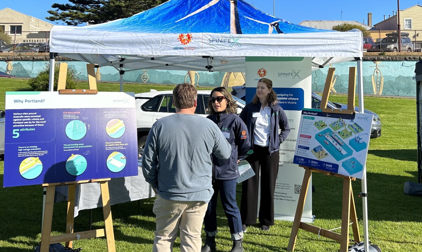 A community stand for the Spinifex Offshore Wind Farm project. A member of the public chats with one of the Spinifex team.